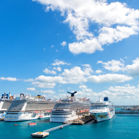 Nassau, Bahamas - February 18, 2016: Large luxury cruise ships of Carnival, Norwegian and Royal Caribbean cruise lines docked in port of Nassau, Bahamas on sea water and cloudy sky background